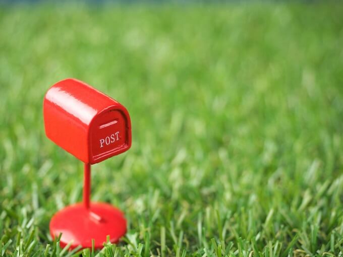 芝生に赤い小さなおもちゃのポスト